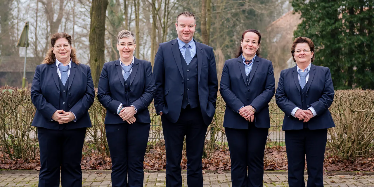 De vijf uitvaartverzorgers van Uitvaartzorg Kremer naast elkaar buiten in Gaanderen